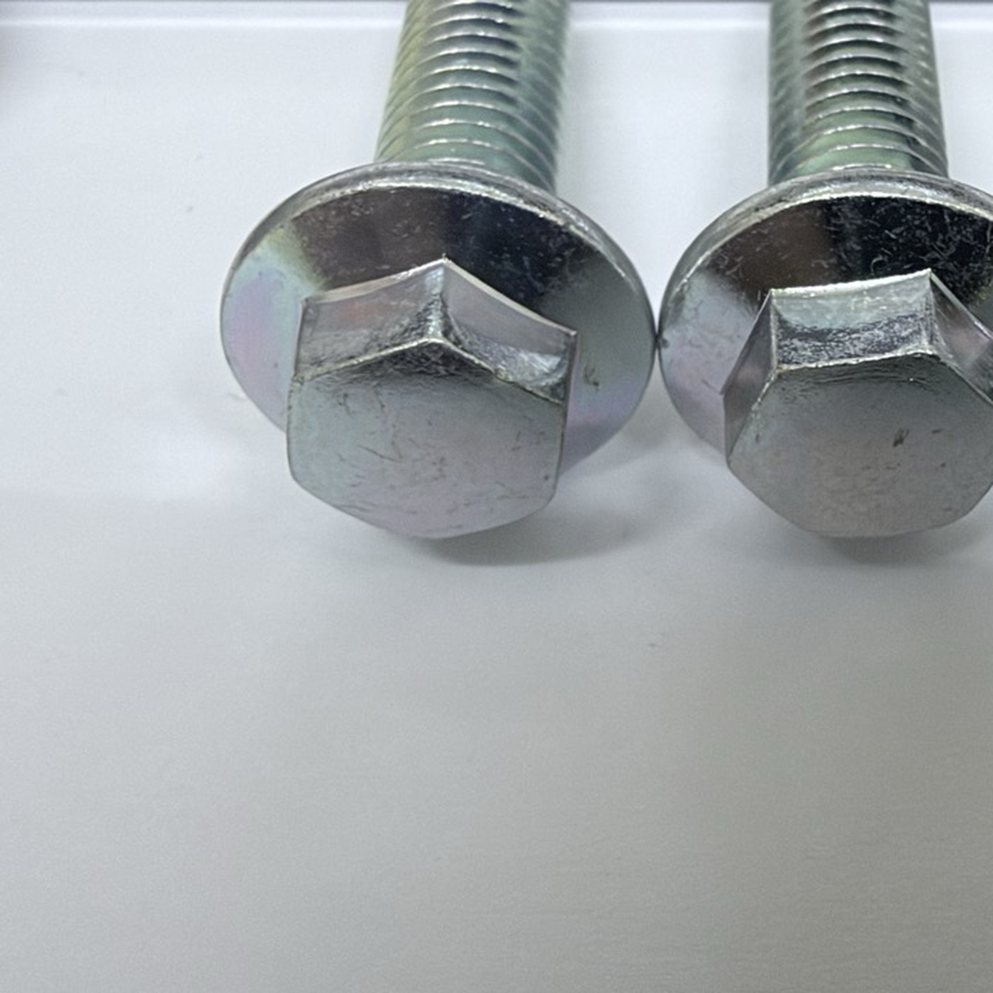Zinc-plated hex flange fastener, head and thread close-up